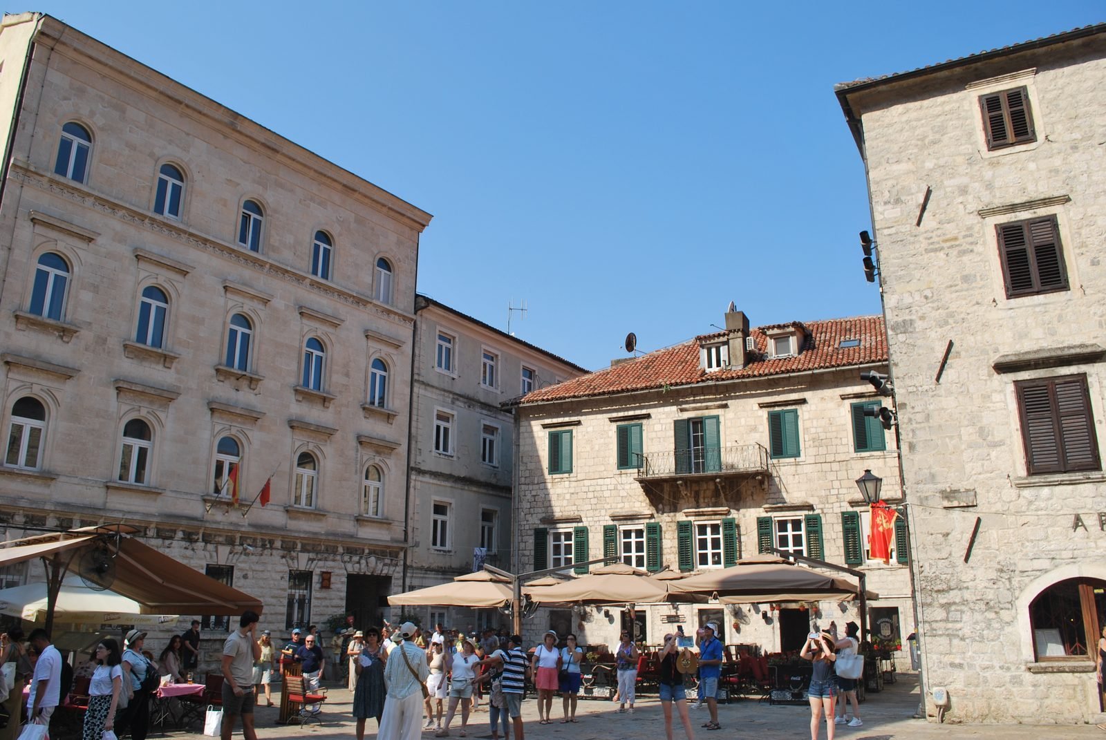 The main square of the Old Town of Kotor, stone façades beneath the mountain
